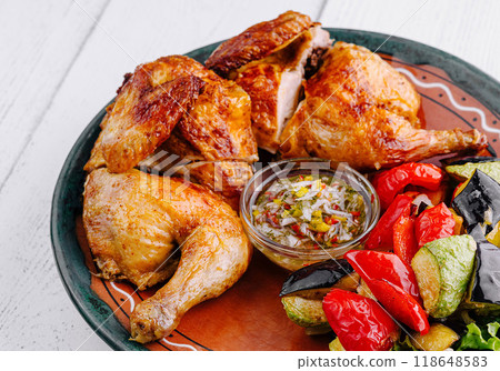 Roasted chicken with vegetables and sauce on rustic plate 118648583