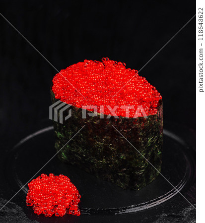 Gunkan maki sushi with red tobiko caviar standing on black plate Gunkan maki sushi with red tobiko caviar standing on black plate 118648622