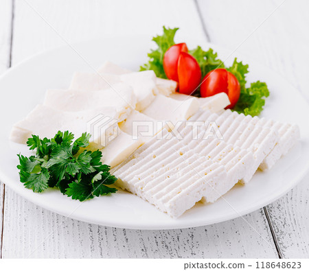 White cheese slices with cherry tomatoes and parsley on white plate White cheese slices with cherry tomatoes and parsley on white plate 118648623