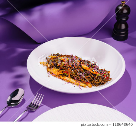 Soba noodles with chicken and vegetables on violet background Soba noodles with chicken and vegetables on violet background 118648640
