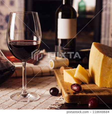 Glass of red wine with cheese and grapes on a table 118648684