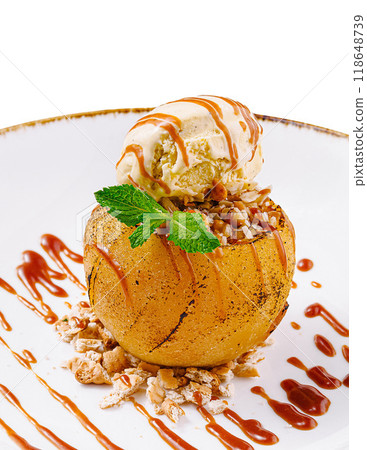 Baked apple dessert with ice cream and caramel sauce on white plate Baked apple dessert with ice cream and caramel sauce on white plate 118648739