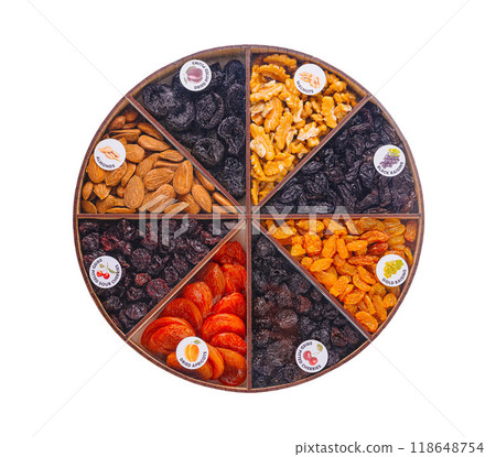 Round wooden compartment tray presenting delectable dried fruits and nuts 118648754