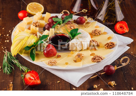 Delicious cheese platter with organic ingredients arranged on wooden table Delicious cheese platter with organic ingredients arranged on wooden table 118648784