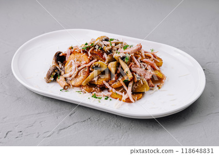 Roasted potatoes with bacon and mushrooms on white plate Roasted potatoes with bacon and mushrooms on white plate 118648831