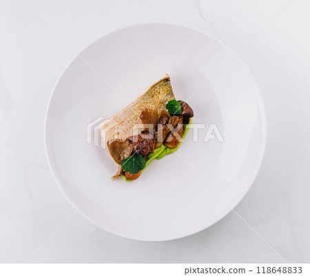 Exquisite restaurant dish with grilled fish and mushrooms on white plate Exquisite restaurant dish with grilled fish and mushrooms on white plate 118648833