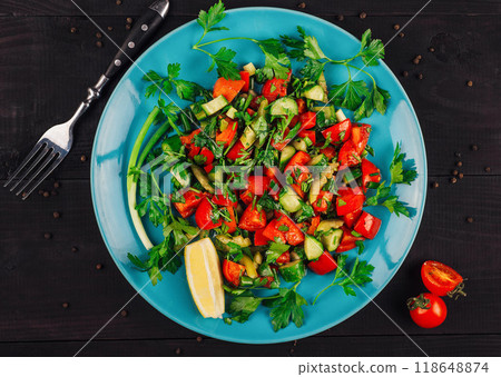 Fresh vegetable salad with herbs and lemon on blue plate Fresh vegetable salad with herbs and lemon on blue plate 118648874
