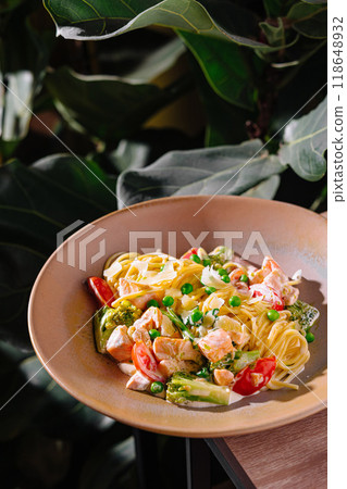 Salmon pasta dish with green peas and parmesan cheese on restaurant table Salmon pasta dish with green peas and parmesan cheese on restaurant table 118648932