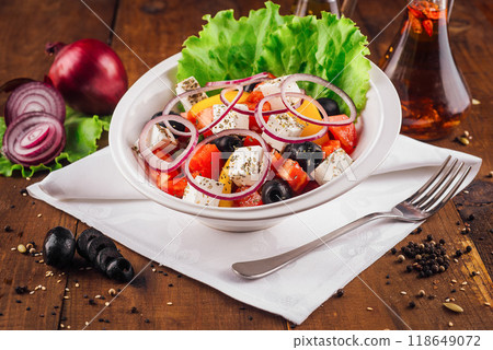Greek salad with feta cheese, vegetables and olives on rustic wooden table background Greek salad with feta cheese, vegetables and olives on rustic wooden table background 118649072