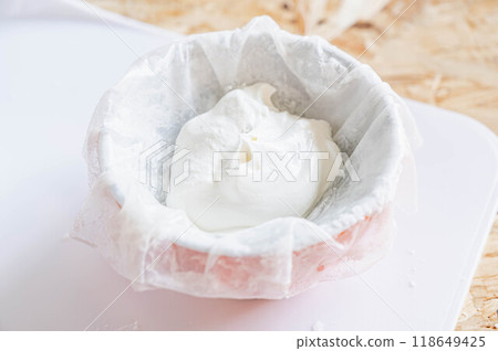 Place spring roll wrappers in a cup and pour cream on top. 118649425