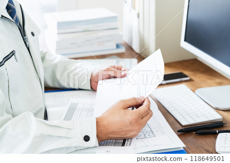 A man in work clothes checking documents 118649501