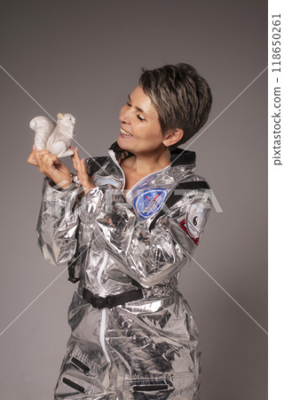 A businesswoman poses in a photo studio in a silver jumpsuit and a black stiletto dress. 118650261