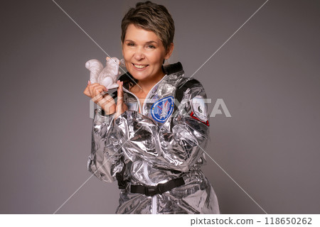 A businesswoman poses in a photo studio in a silver jumpsuit and a black stiletto dress. 118650262