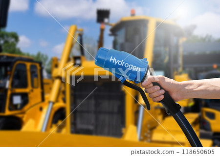 Hand with hydrogen fueling nozzle on a background of fuel cell construction machines. Concept. 118650605