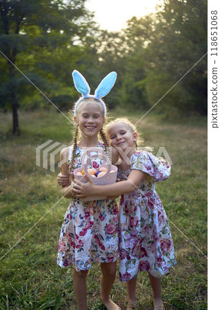 two little girls hug and play bunnies on  Easter egg hunt 118651068
