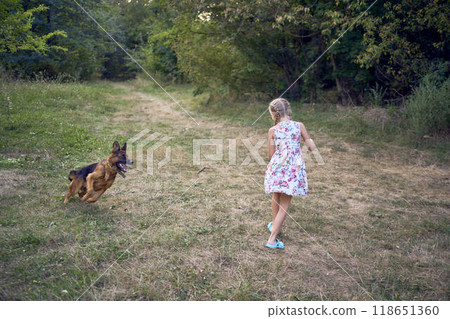 little girls sisters play with german shepherd dog during easter picnic in the garden 118651360