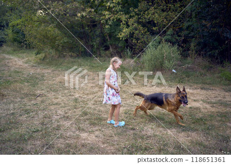 little girls sisters play with german shepherd dog during easter picnic in the garden 118651361