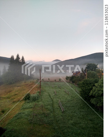 Village in mountains with the view on forest of fir mountains in fog rural vertical 118653023