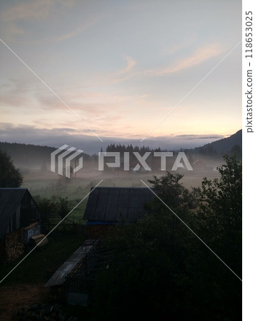 Village in mountains with the view on forest of fir mountains in fog rural vertical 118653025