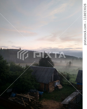 Village in mountains with the view on forest of fir mountains in fog rural vertical 118653026