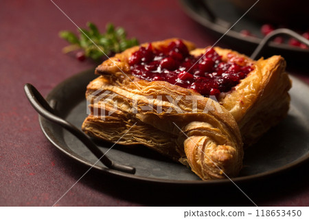 A delicious dessert, puff pastry cake with berry filling. Cranberry dessert, close-up A delicious dessert, puff pastry cake with berry filling. Cranberry dessert, close-up 118653450