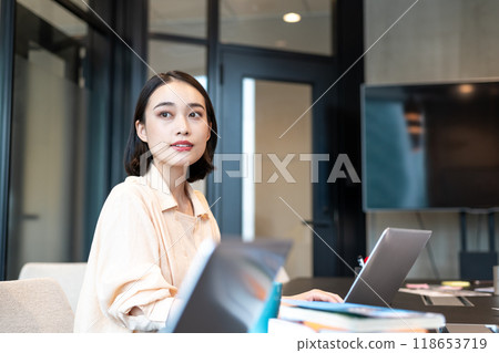 A woman looking at the view from the window during a break from working on her computer A woman looking at the view from the window during a break from working on her computer 118653719