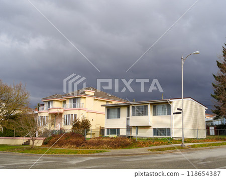 The street corner with two residential houses on stormy sky background 118654387