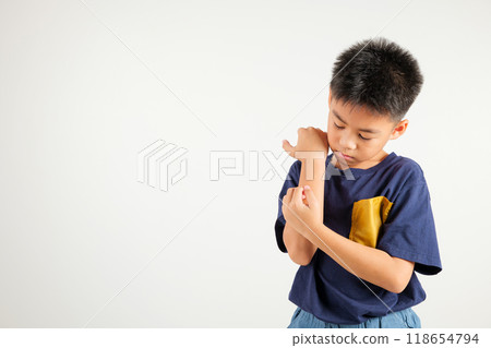 Asian little kid boy scratching itchy arm from a mosquito bite at studio shot isolated on white background, Portrait of Thai primary child dermatitis and scabies, Allergy symptoms, Malaria day concept Asian little kid boy scratching itchy arm from a mosquito bite at studio shot isolated on white background, Portrait of Thai primary child dermatitis and scabies, Allergy symptoms, Malaria day concept 118654794