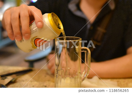pouring can of beer into mug pouring can of beer into mug 118656265