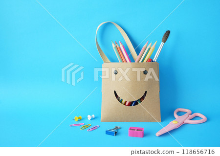 Back to school paper bag with colors pencil and stationary stuff with blue background Back to school paper bag with colors pencil and stationary stuff with blue background 118656716