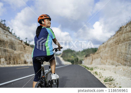 female biker riding bike on road female biker riding bike on road 118656961