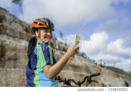 female cyclist riding bike and using phone female cyclist riding bike and using phone 118656981