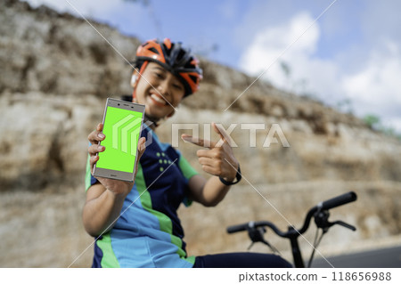 female biker pointing green screen mockup phone 118656988