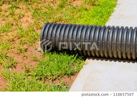 Installation of plastic black pipes for flow of rainwater to rainwater collection system Installation of plastic black pipes for flow of rainwater to rainwater collection system 118657507