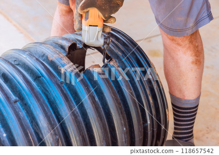 Cutting hole in black plastic polypropylene sanitary pipe to connect another pipe 118657542