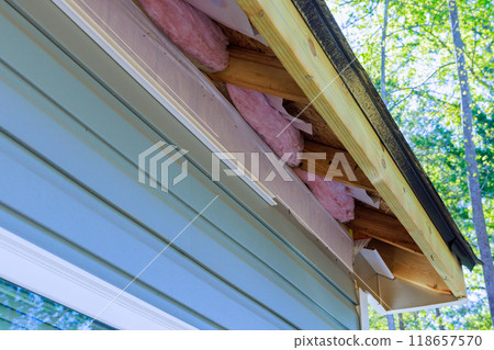 During exterior house remodel reconstruction of house, damaged plastic siding is replaced 118657570
