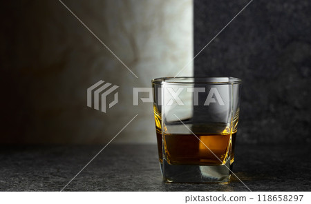 Glass of whiskey on a black table. 118658297