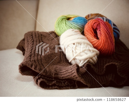 Colorful balls of yarn on a chair, reminiscent of knitting Colorful balls of yarn on a chair, reminiscent of knitting 118658627