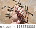 selective focus at the female hand, holding screws 118658888