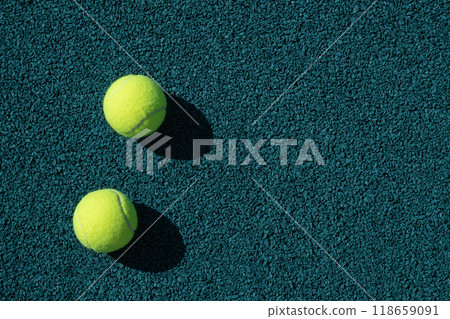 Two yellow tennis balls on green sports ground with artificial grass covering. Close up. Copy space. Healthy lifestyle concept. 118659091