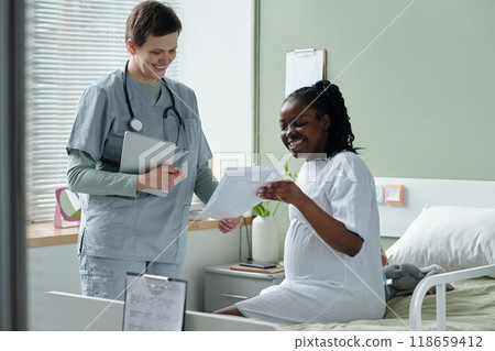 Doctor and Patient Smiling While Discussing Health Plans 118659412
