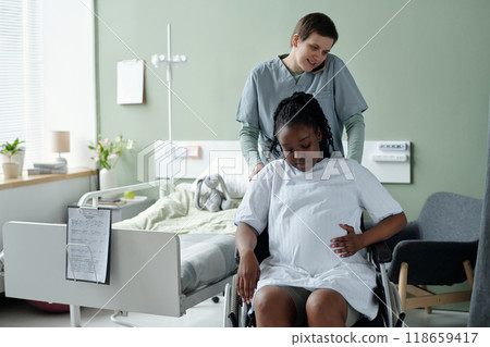 Assisting Woman on Wheelchair in Hospital Room 118659417