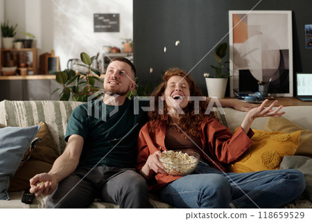 Dates having fun with popcorn on sofa Dates having fun with popcorn on sofa 118659529