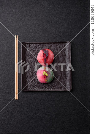 Delicious cold Japanese mochi dessert with colorful rice dough shell and fruit filling Delicious cold Japanese mochi dessert with colorful rice dough shell and fruit filling 118659845