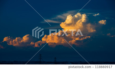 積雨雲在夕陽下閃閃發光,隨著它的生長而改變形狀 積雨雲在夕陽下閃閃發光,隨著它的生長而改變形狀 118660917