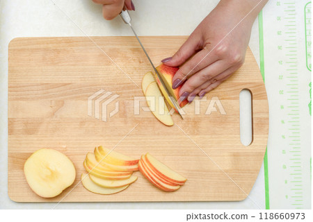 Slicing apples on a wooden cutting board. 118660973