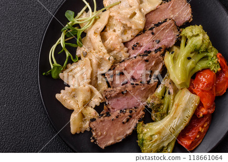 Bowl with slices of baked tuna with broccoli, tomatoes and fusili pasta 118661064