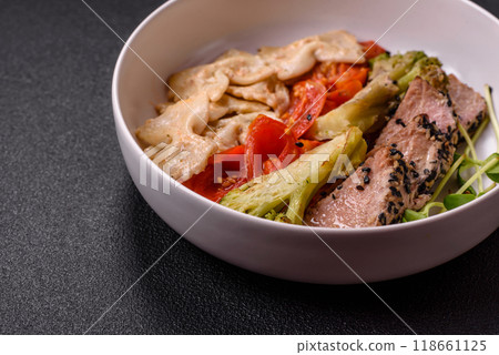 Bowl with slices of baked tuna with broccoli, tomatoes and fusili pasta 118661125