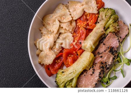 Bowl with slices of baked tuna with broccoli, tomatoes and fusili pasta 118661126