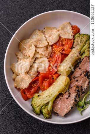 Bowl with slices of baked tuna with broccoli, tomatoes and fusili pasta 118661127